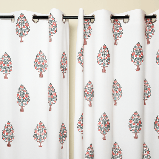 White cotton curtain with repeated pink tree block print, hanging on black grommet rod