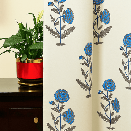 Handprinted cotton curtain with blue floral block print next to a red planter