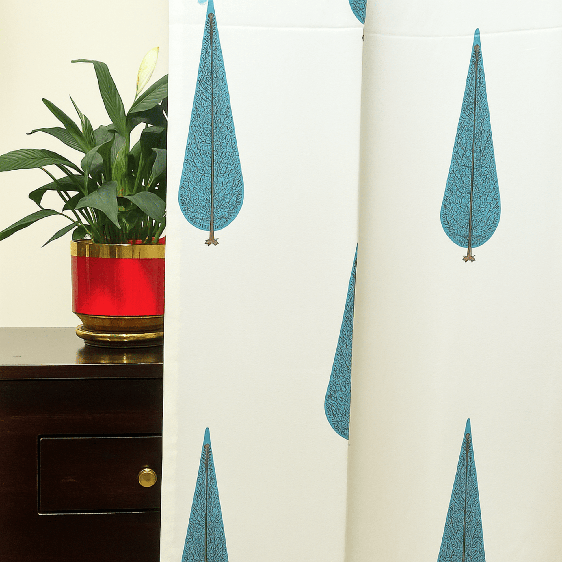 Cotton curtain with blue cypress tree block print next to a red planter