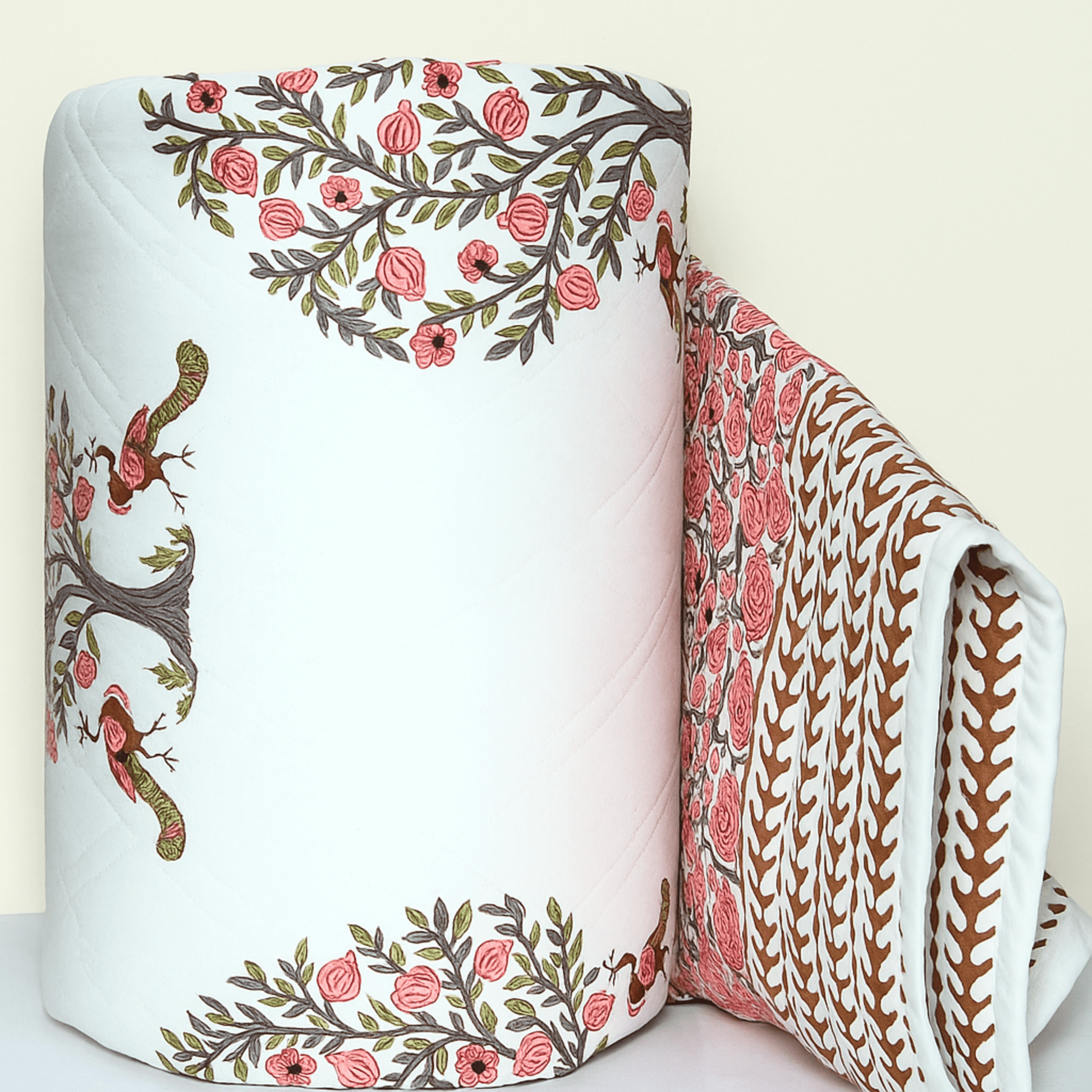 Rolled cotton quilt showcasing pink pomegranate tree with peacocks and contrasting printed border