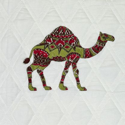 Detailed view of a red and green handprinted camel block on white quilted cotton fabric.