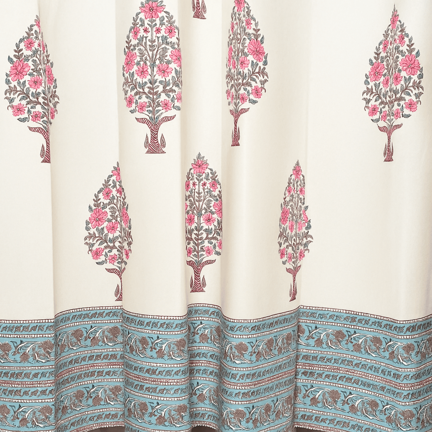 Handprinted curtain with pink floral tree motifs and blue printed border at the hem

