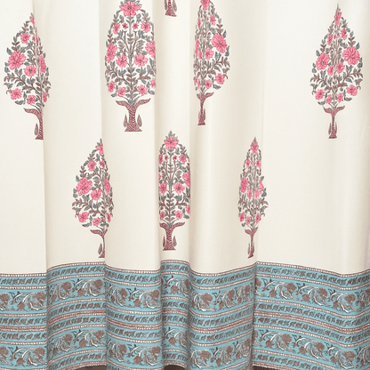 Handprinted curtain with pink floral tree motifs and blue printed border at the hem

