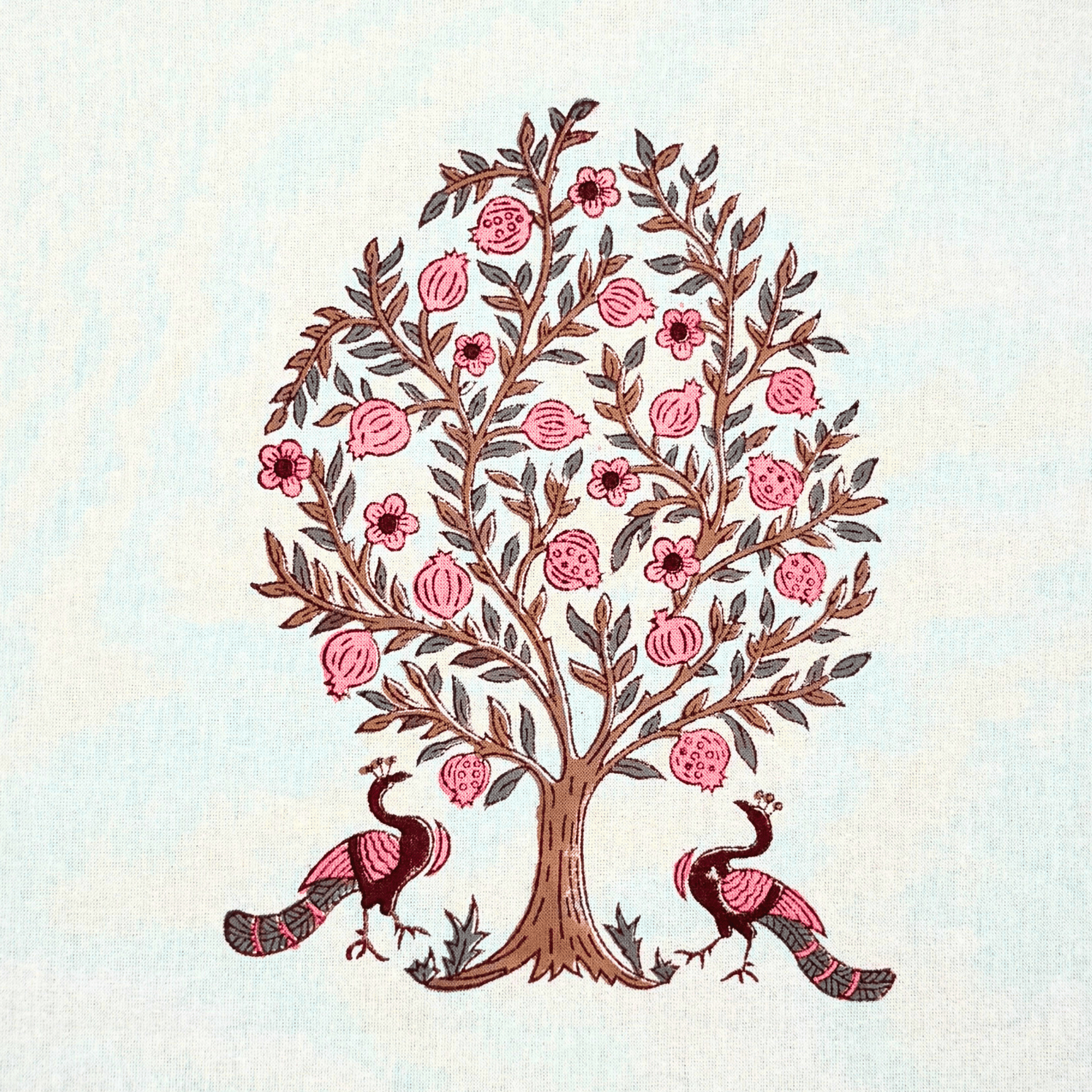 Detailed view of pink peacock and pomegranate tree handblock motif on white cotton fabric