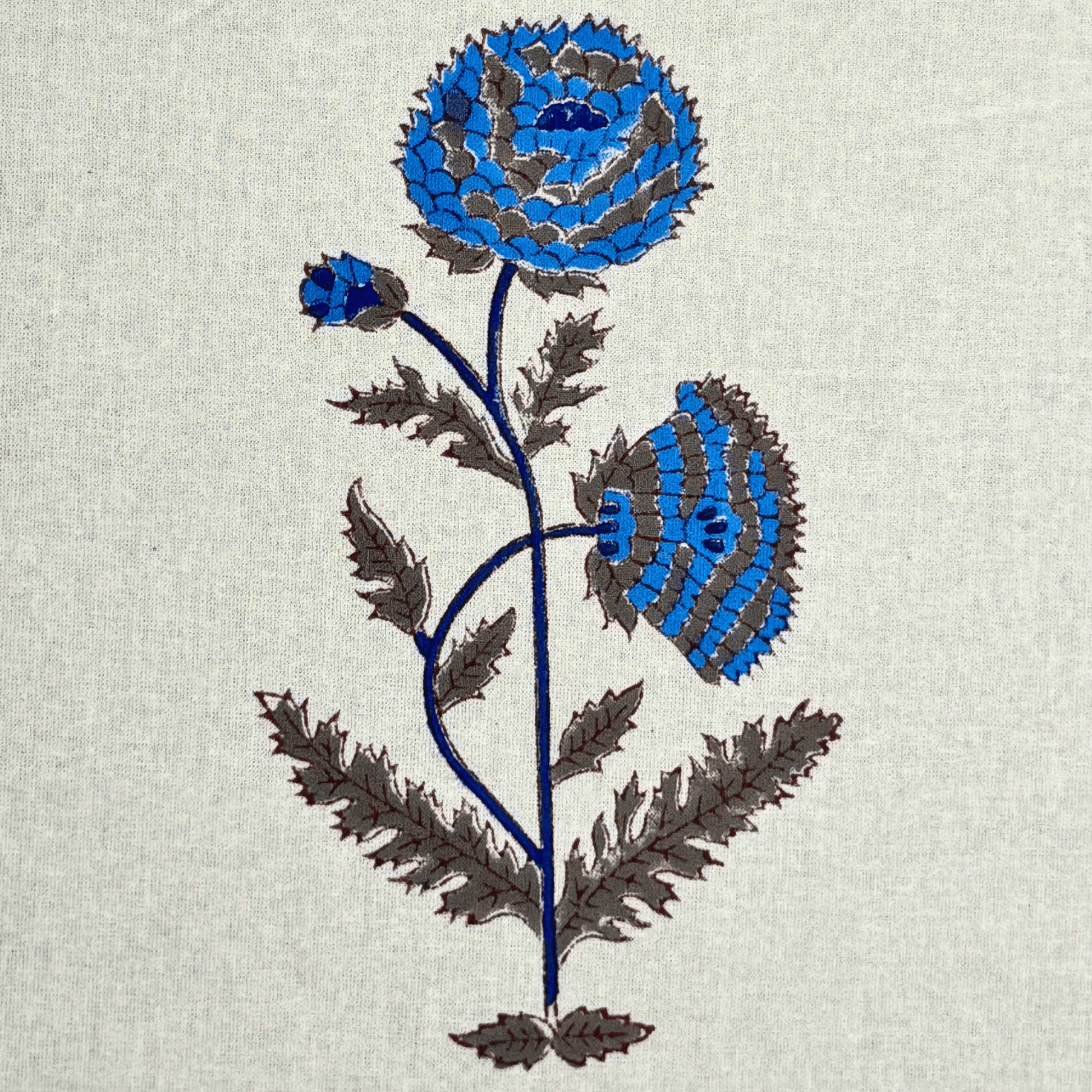 Detailed view of blue handblock printed flower on cotton curtain fabric